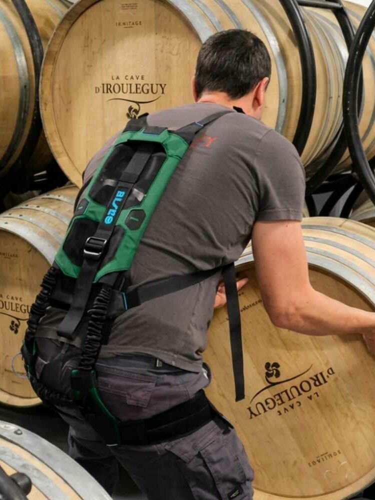 Exosquelette dos BISKO port&eacute; par un viticulteur au chai